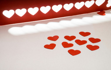 Decoration for Valentine's Day: hole puncher made paper shapes of red hearts