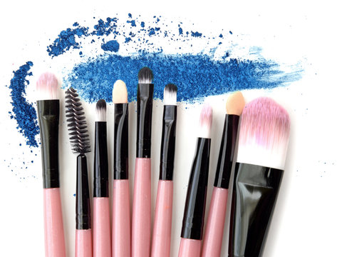 Various makeup brushes on crushed blue powder make up