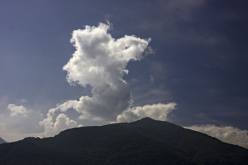 Cumulus cloud rises from the top of the mountain.