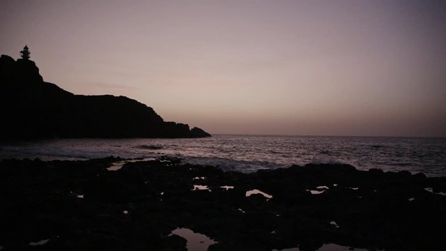 Sunset at rocky seashore.