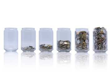 Mix foreign coins in clear bottle isolated on white background, Business investment and banking growth concept.