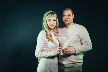 Man and woman in a white dresses lighted colored light in studio and black background