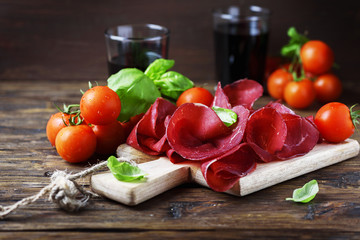 Dish of italian traditional bresaola with red wine