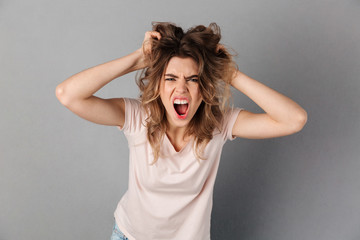 Angry woman in t-shirt screaming and holding her hair