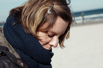 Frau mit Haarspange im Winter am Strand