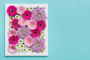 Picture frame filled with different gerberas and daisies. Happy Mother's Day, Women's Day, Valentine's Day or Birthday Pastel Candy Colors Background with copy space.