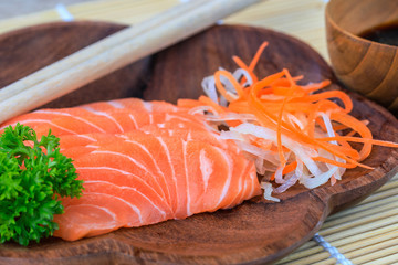 Salmon sashimi in wooden bowl on the table.