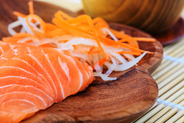 Salmon sashimi in wooden bowl on the table.