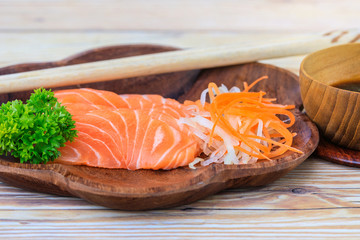 Salmon sashimi in wooden bowl on the table.