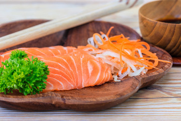 Salmon sashimi in wooden bowl on the table.