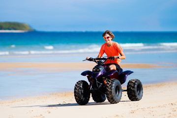 Fototapeta na wymiar Teenager riding quad bike on beach