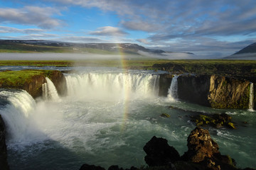 rainbow over godafoss waterfall early in the morning