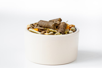 dry food for rodents in bowl white background