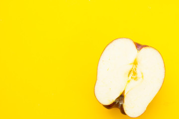 Delicious fruit: fresh juicy apple cut in half on a yellow background with copy space, top view