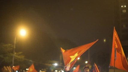 Football fan frantically waves a Vietnam flag in celebration after the AFC U23 finals