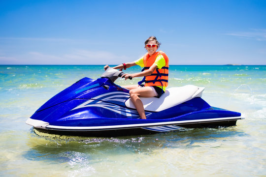 Teenager On Jet Ski. Teen Age Boy Water Skiing.