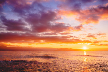 Bright sunset or sunrise in ocean. Landscape with warm sunset or sunrise colors