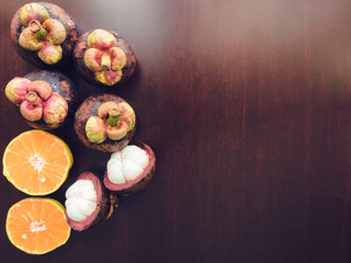overhead view skin and texture of mangosteen with peel and orange on wood background