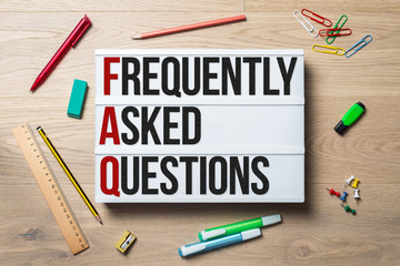 Frequently asked questions written on lightbox lying on desk