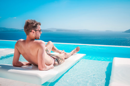 young man at the swimpool during vacation at Santorini Greece