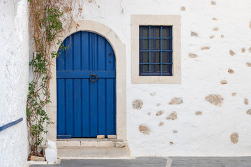 Old wooden door on white stone wall.
