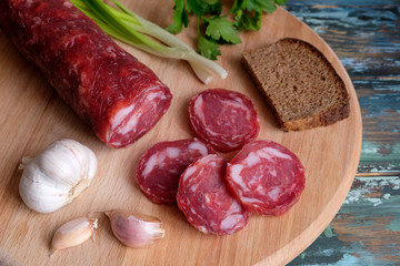 smoked sausage, salami on a wooden table
