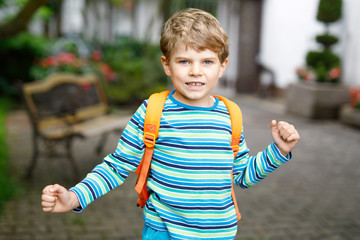 little kid boy with school satchel on first day to school