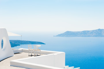 Two chairs on the terrace with sea views. Santorini island, Greece. Travel and vacation background