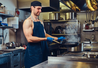 The chef preparing meat on a dry pan.