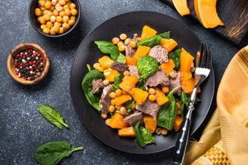 Warm salad with pumpkin, baked beef, spinach and chickpeas.