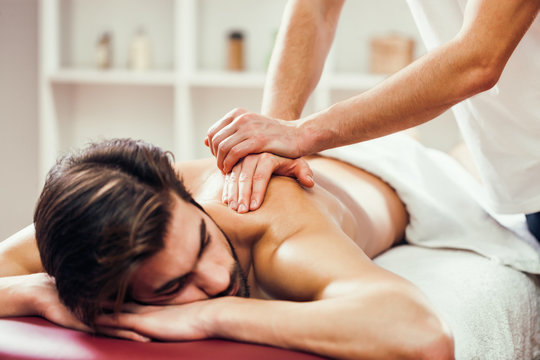 Young man is enjoying massage on spa treatment. 