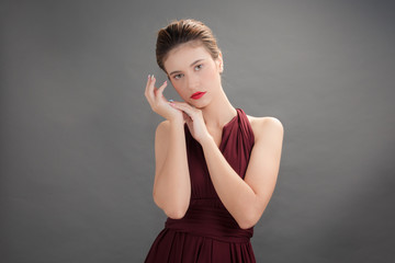 Fototapeta premium Beautiful woman wearing red dress on gray background for Beauty and spa concept