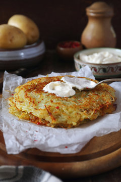 French cuisine. Pomme darphin: roasted pancakes from raw grated potatoes  with sour cream. Rustic style