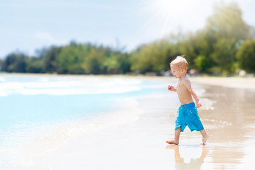 Child on tropical beach. Sea vacation with kids.