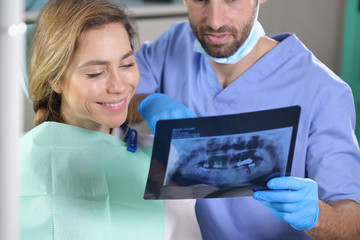 00:00 | 00:13 1× In a professional practice, a dentist checks the patient's denture plate, and she smiles happily, showing her perfect smile. Concept of: dentists, healthcare, medical examination.
