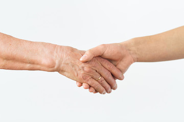 close up of senior and young woman holding hands