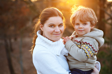 Mother and little son in park or forest, outdoors.