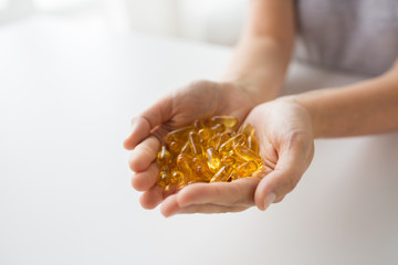 Obraz premium hands holding cod liver oil capsules