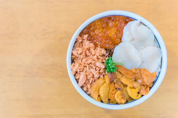 Japanese food with raw fishes ,Sea urchin and scallop called sashimi on the rice in Bowl in Hakodate morning market, Hokkaido, Japan.