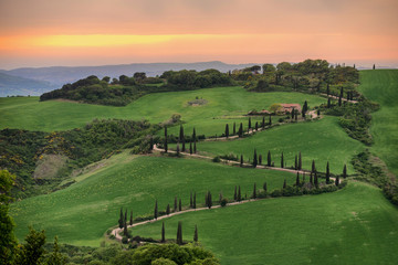Fototapeta na wymiar Tuscany, rural sunset landscape. Countryside farm, cypresses trees, green field,Italy, Europe.