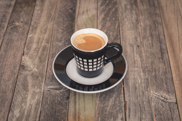 Single small coffee cup on wooden background