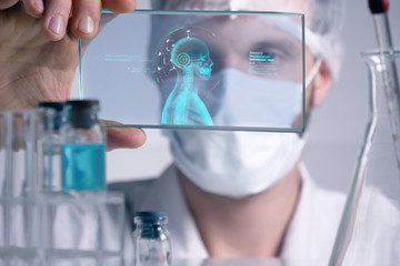 A physician, surgeon, examines a technological digital holographic plate represented the patient's body, the heart lungs, muscles, bones. Concept: Futuristic medicine, the human body, and the future.