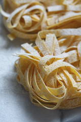 Close-up of the uncooked Italian pasta on a white marble table.
