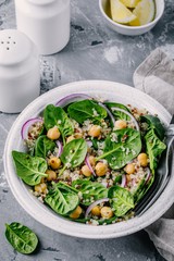 Healthy green salad bowl with spinach, quinoa, chickpeas and red onions
