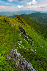 Obraz premium mountain behind the valley viewed from rocky cliff. beautiful summer landscape with grassy slopes under the cloudy sky. location mountain Pikui, TransCarpathia, Ukraine