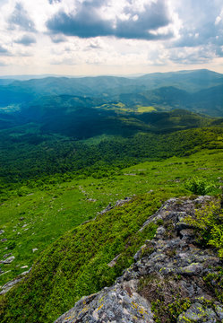 mountain behind the valley viewed from rocky cliff. beautiful summer landscape with grassy slopes under the cloudy sky. location mountain Pikui, TransCarpathia, Ukraine