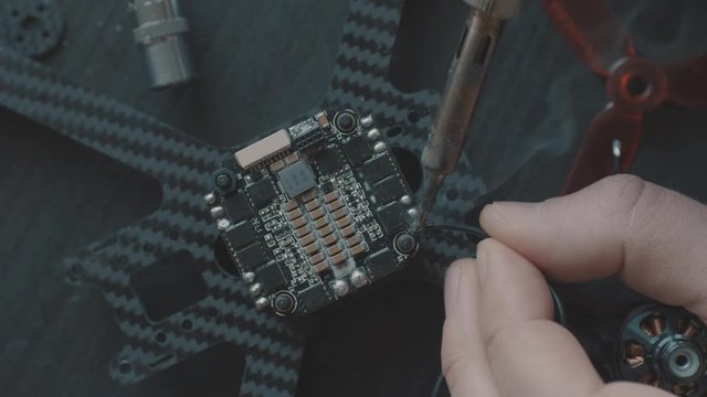 Soldering FPV Racing Drone Brushless Motor on a ESC. Overhead Shot.