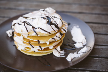Image of some pancakes served on a plate on a wooden table.