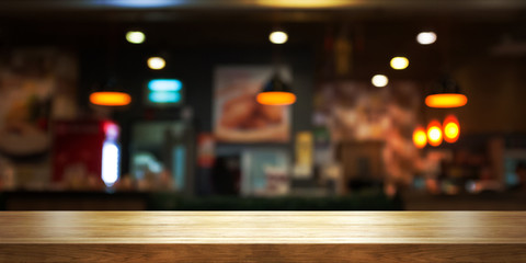 Empty wooden table top with blur coffee shop or restaurant interior background, Panoramic banner.