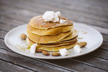 Image of some pancakes served on a plate on a wooden table.